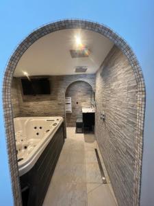 an arched bathroom with a tub and a sink at Le Petit Cocon in Amiens