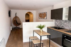 a kitchen with a table and chairs in a room at Le Petit Cocon in Amiens