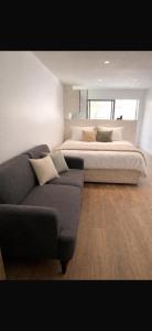 a bedroom with a large bed and a couch at Le Petit Cocon in Amiens