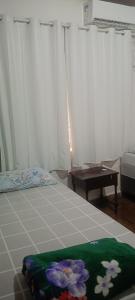 a bedroom with a bed and a table in a room at Pousada Popular in Barreiras