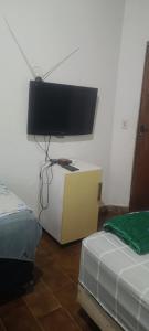 a room with two beds and a flat screen tv at Pousada Popular in Barreiras