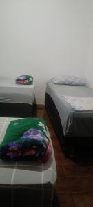 a room with two twin beds sitting next to each other at Pousada Popular in Barreiras