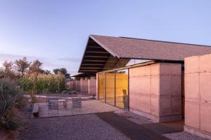 a building with a yellow door and a table and chairs at Fauna Atacama in San Pedro de Atacama