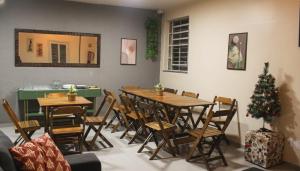 a room with a table and chairs and a christmas tree at Vintagyn Hostel in Goiânia