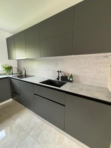 a kitchen with gray cabinets and a sink at Hygge in Neumünster