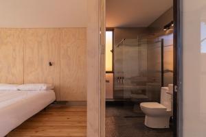 a bathroom with a bed and a shower and a toilet at Fauna Atacama in San Pedro de Atacama