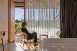 a woman sitting in a chair in front of a window at Fauna Atacama in San Pedro de Atacama