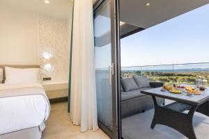 a bedroom with a bed and a table and a couch at FOGE luxury villa Agios Onoufrios in Chania +86 photos