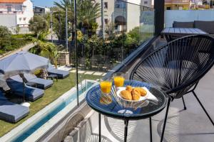 a table with a basket of bread and two glasses of orange juice at FOGE luxury villa Agios Onoufrios in Chania