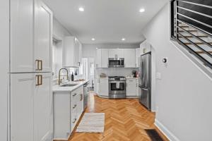 a kitchen with white cabinets and stainless steel appliances at Spacious 3BR Near Art Museum Patio Gameroom in Philadelphia