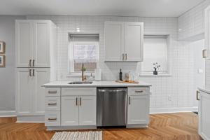 a kitchen with white cabinets and a stainless steel dishwasher at Spacious 3BR Near Art Museum Patio Gameroom in Philadelphia +36 photos