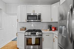 a white kitchen with a stove and a microwave at Spacious 3BR Near Art Museum Patio Gameroom in Philadelphia