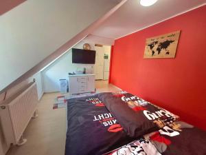 a bedroom with a bed in a red wall at KissApartman in Kőszeg