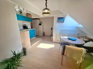 a kitchen with a table and a kitchen with blue cabinets at KissApartman in Kőszeg
