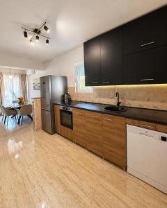 a kitchen with black cabinets and a dining room at Apartman VUKAN in Budva