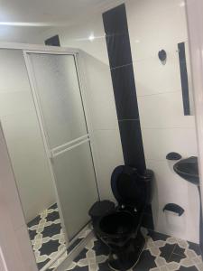 a bathroom with a black toilet and a sink at Hotel Pacífico Azul in Bahía Solano