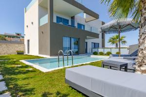 a backyard with a swimming pool and a house at FOGE luxury villa Agios Onoufrios in Chania