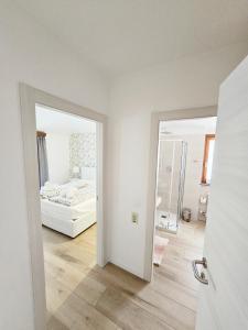 an open door to a bedroom with a bed and a mirror at Casa Barcelli Sport & Family Apartments in Nago-Torbole +106 photos