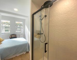 a bathroom with a shower and a bed in a room at El Patio de María in Ferrol
