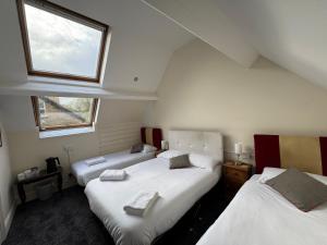 two beds in a room with two windows at The Briary in Sheffield