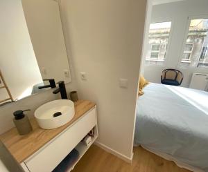 a bedroom with a bed and a sink and a mirror at El Patio de María in Ferrol