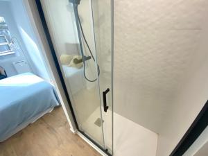 a glass shower door in a room with a bed at El Patio de María in Ferrol +36 photos