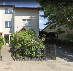 a house with a gate in front of a building at Apartament przy Koniu Trojańskim in Luboń