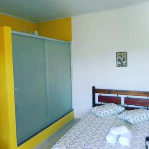 a bedroom with a bed with a large glass wall at Pousada Oritibe in Cairu