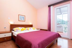 a bedroom with a bed and a large window at Apartment Bezerusa in Igrane