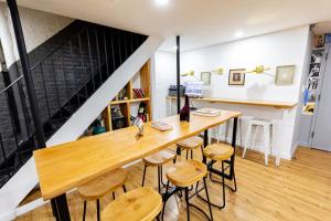 a dining room with a wooden table and stools at JGSTAY - Times Square in New York