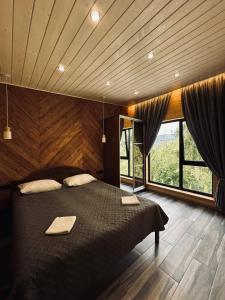 a bedroom with a large bed and a large window at Love's Mount Resort in Slavske