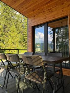 a wooden deck with a table and chairs on it at Love's Mount Resort in Slavske
