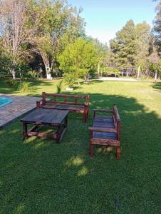 two benches and a picnic table in a park at Sítio do Berger 1 in São Gabriel