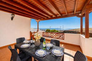 a dining room with a table and chairs and a balcony at Casa Morro Blanco in Conil