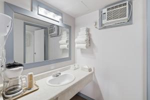 a bathroom with a sink and a mirror at Canada's Best Value Desert Inn & Suites in Cache Creek +82 photos
