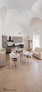a living room with white tables and white chairs at Domus Avi - Bed and Breakfast in Taviano