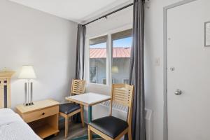 a bedroom with a desk and chairs and a window at Canada's Best Value Desert Inn & Suites in Cache Creek
