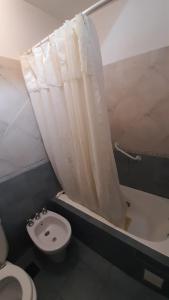 a bathroom with a toilet and a shower curtain at Casamira in Rosario