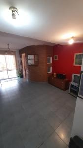 an empty living room with a red wall and a brick wall at Casamira in Rosario