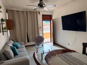 a living room with a couch and a flat screen tv at Departamento completo bien ubicado in Minatitlán