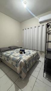 a bedroom with a bed with a cat laying on it at Studio Confortável no Centro com Garagem in Araquari