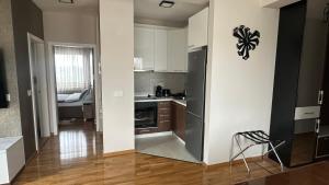 a kitchen with a stainless steel refrigerator in a room at SiM Lux in Čačak