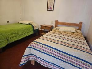 a bedroom with two beds and a green bed at Real Casona Chacas in Chacas