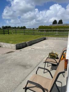 two benches sitting on top of a parking lot at Island Place in Castleisland +7 photos