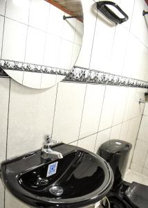 a bathroom with a black sink and a trash can at Apartaestudio equipado en Duitama sector UPTC in Duitama