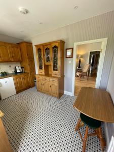 a kitchen with wooden cabinets and a table at Island Place in Castleisland