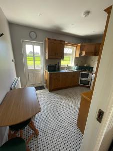 a kitchen with wooden cabinets and a table and a window at Island Place in Castleisland