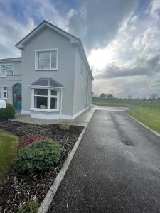 a white house with a driveway in front of it at Island Place in Castleisland