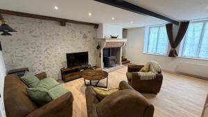 a living room with two couches and a fireplace at Gîte de La Petite Mauve in Baule