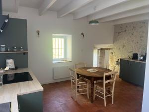 a kitchen with a table and chairs in a room at Gîte de La Petite Mauve in Baule